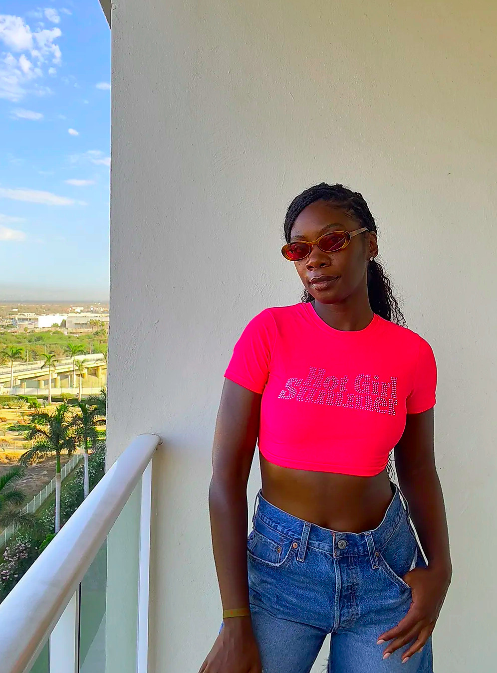 Byrdie editor wearing a pink bedazzled crop top