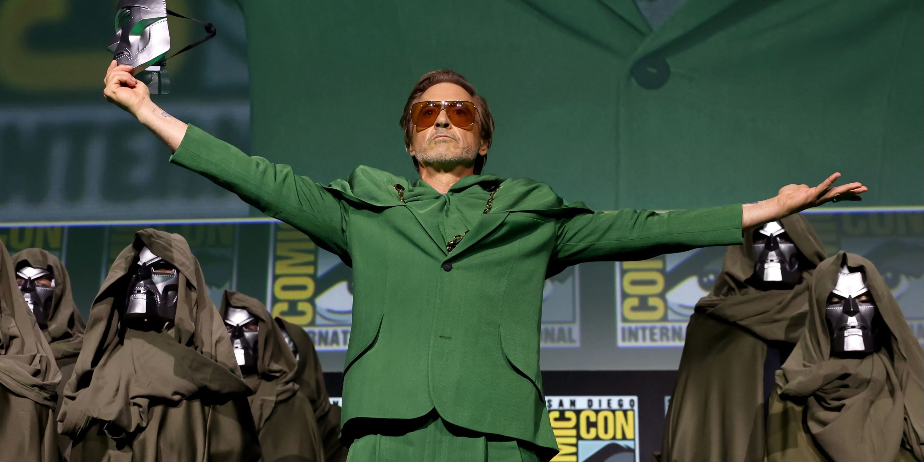 Robert Downey Jr as Dr Doom, holding his hands out at comic con san diego