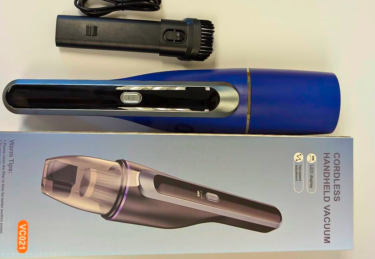 A blue cordless handheld vacuum cleaner with accessories and packaging.