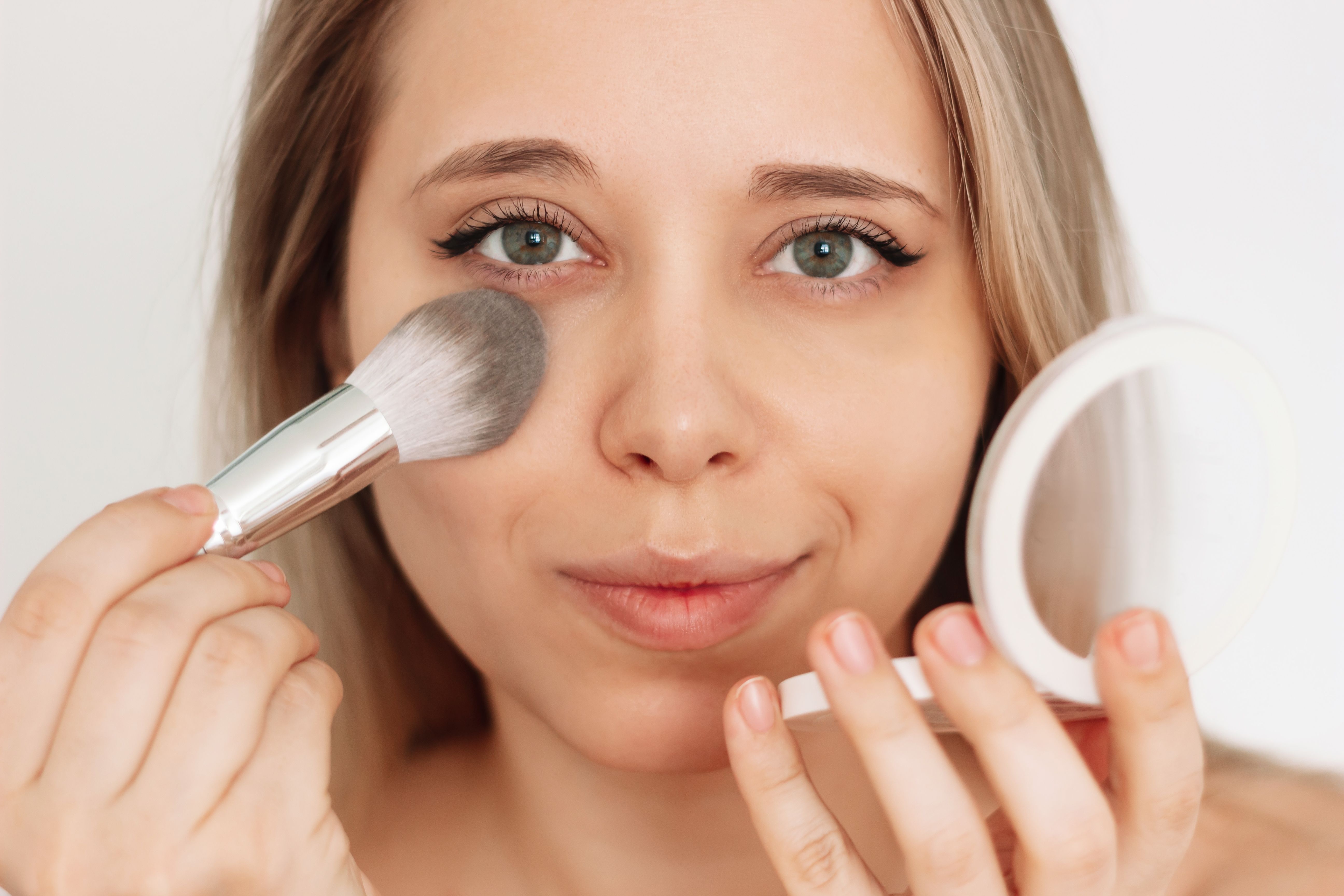 Woman putting on light make-up