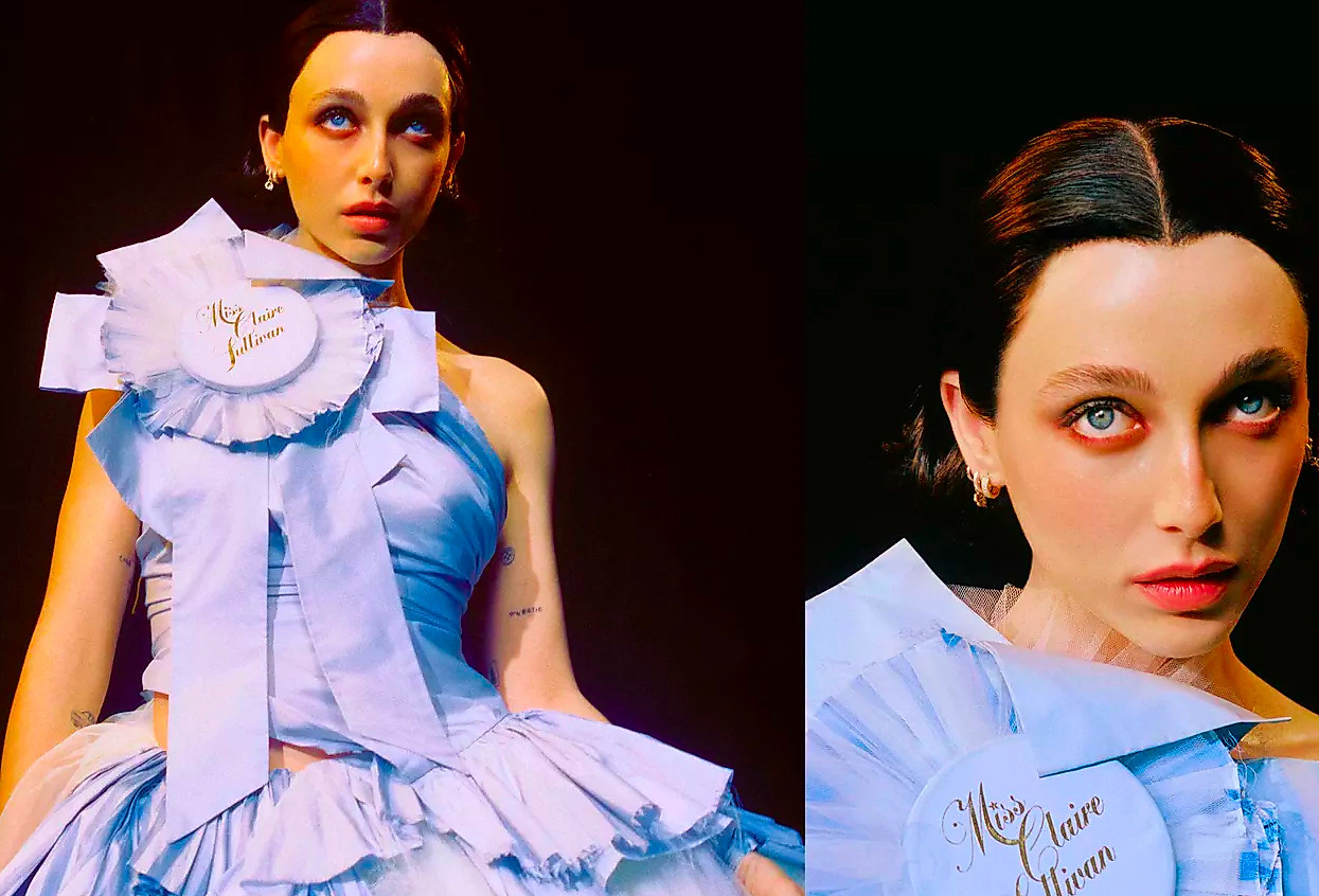Emma Chamberlain posing in a victorian dress with black hair and a ribbon that says Miss Claire Sullivan