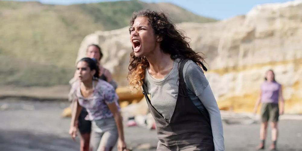 A girl on the beach yells out in frustration as other girls watch in The Wilds