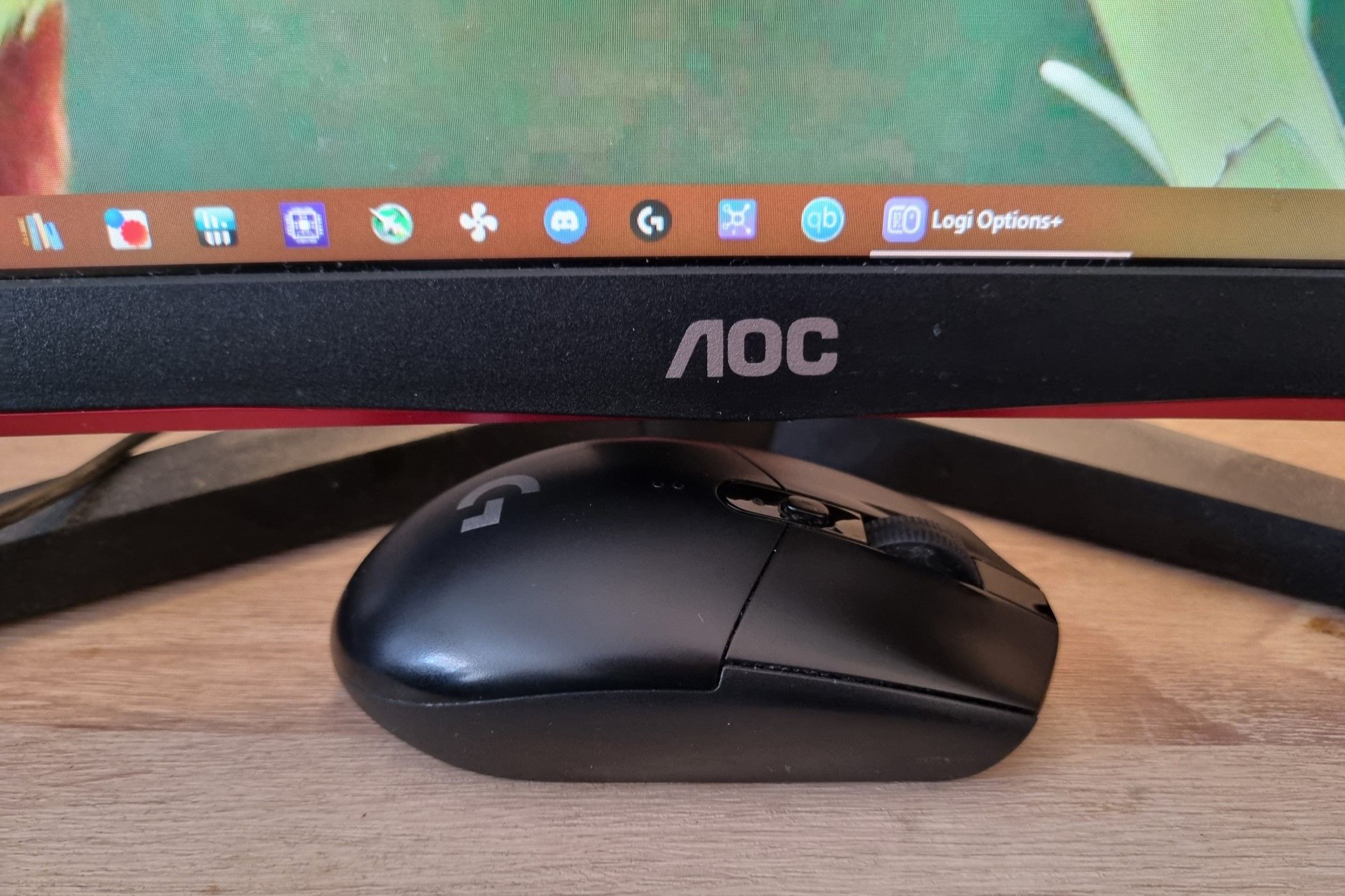 A Logitech G305 residing under a monitor.