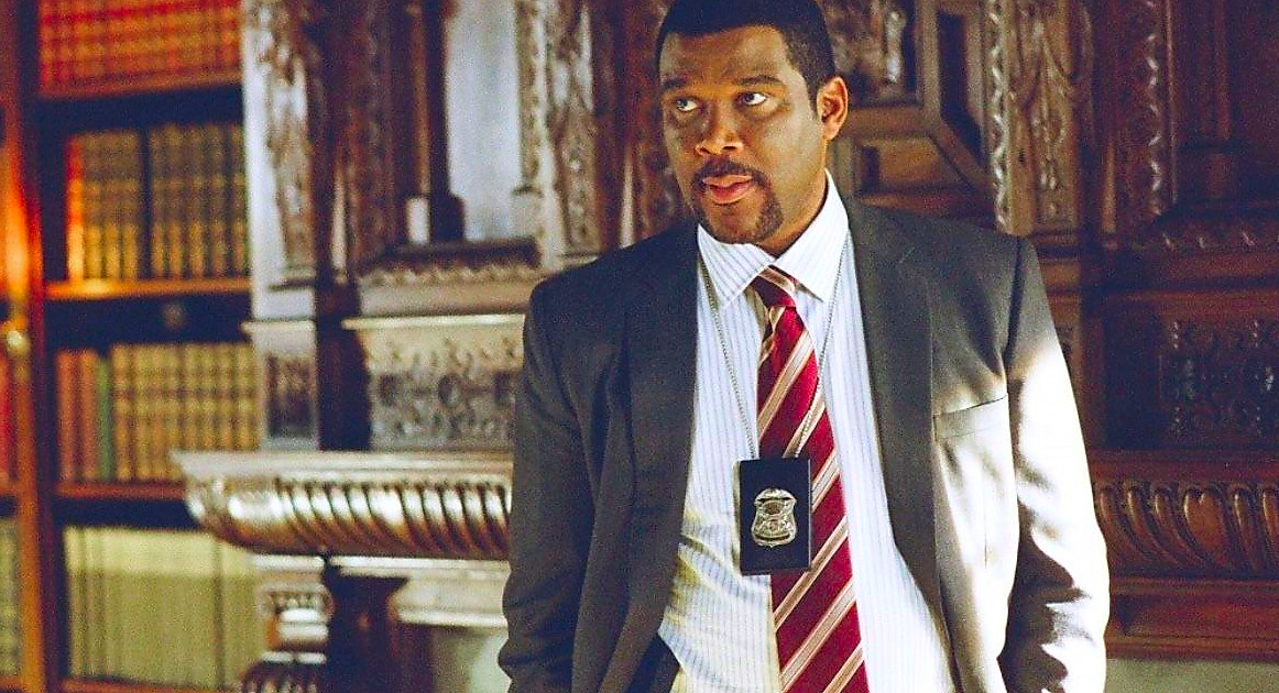 Tyler Perry wearing a badge as Alex Cross