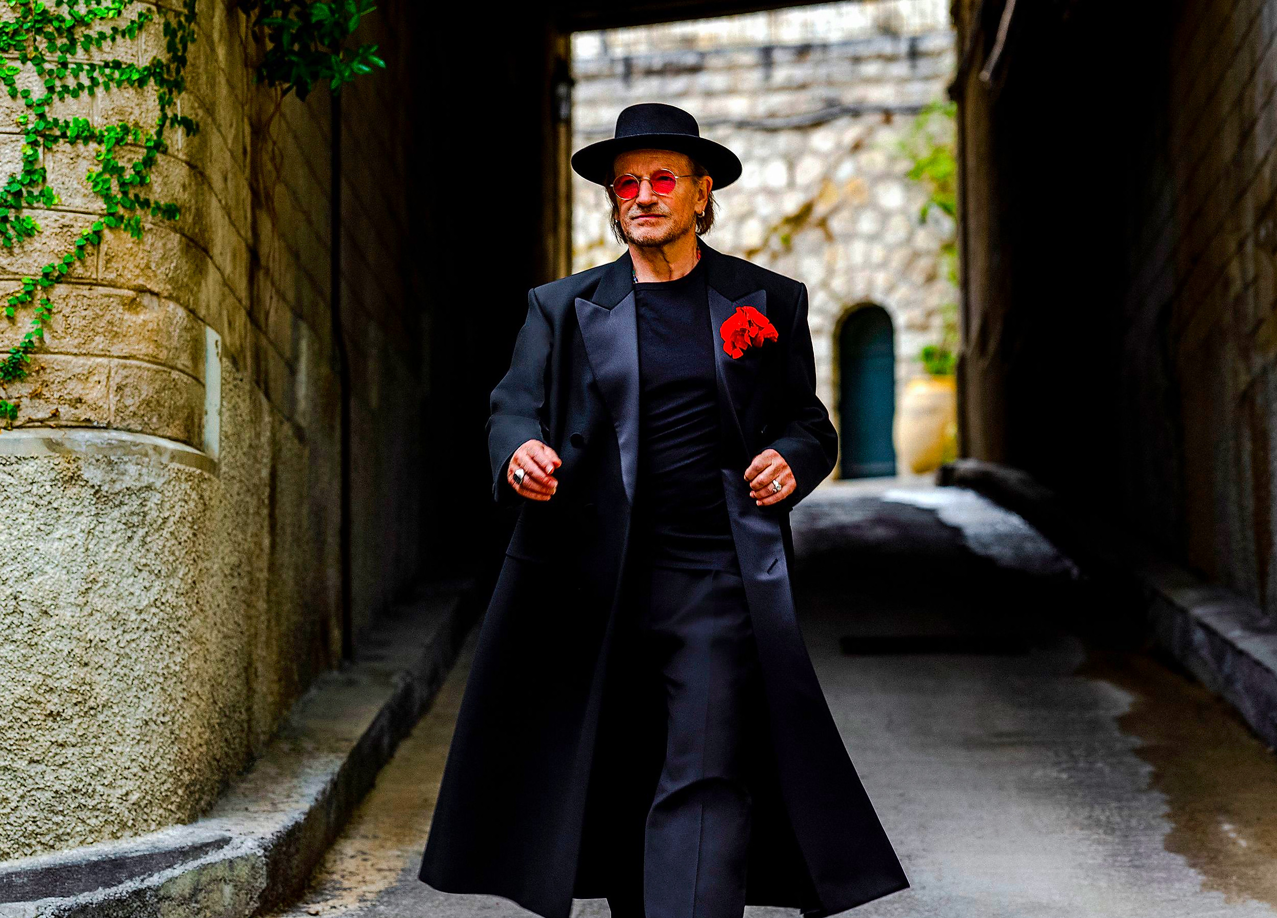 a stylish figure walking through a narrow alleyway