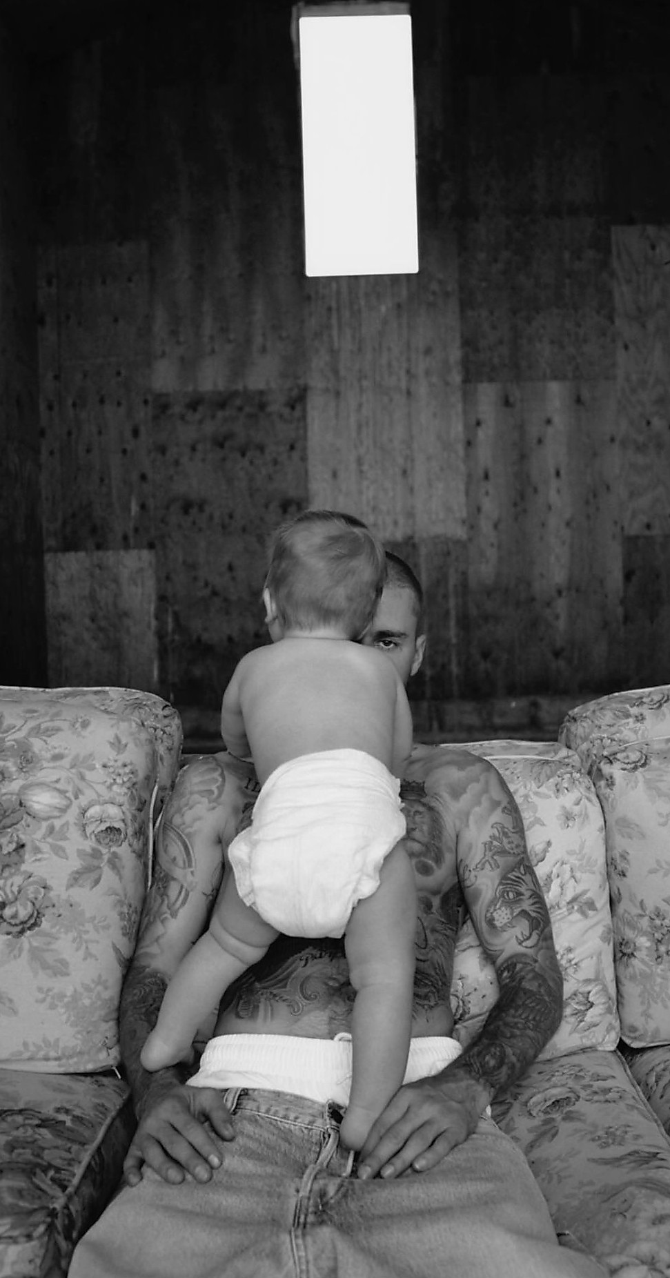 a person sitting on a couch with a baby on their lap