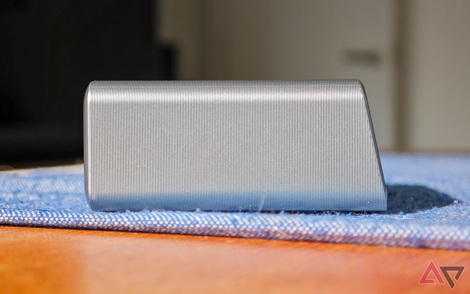 Anker Prime 250W desktop charger sitting on a blue cloth on a wooden table, seen from the side on