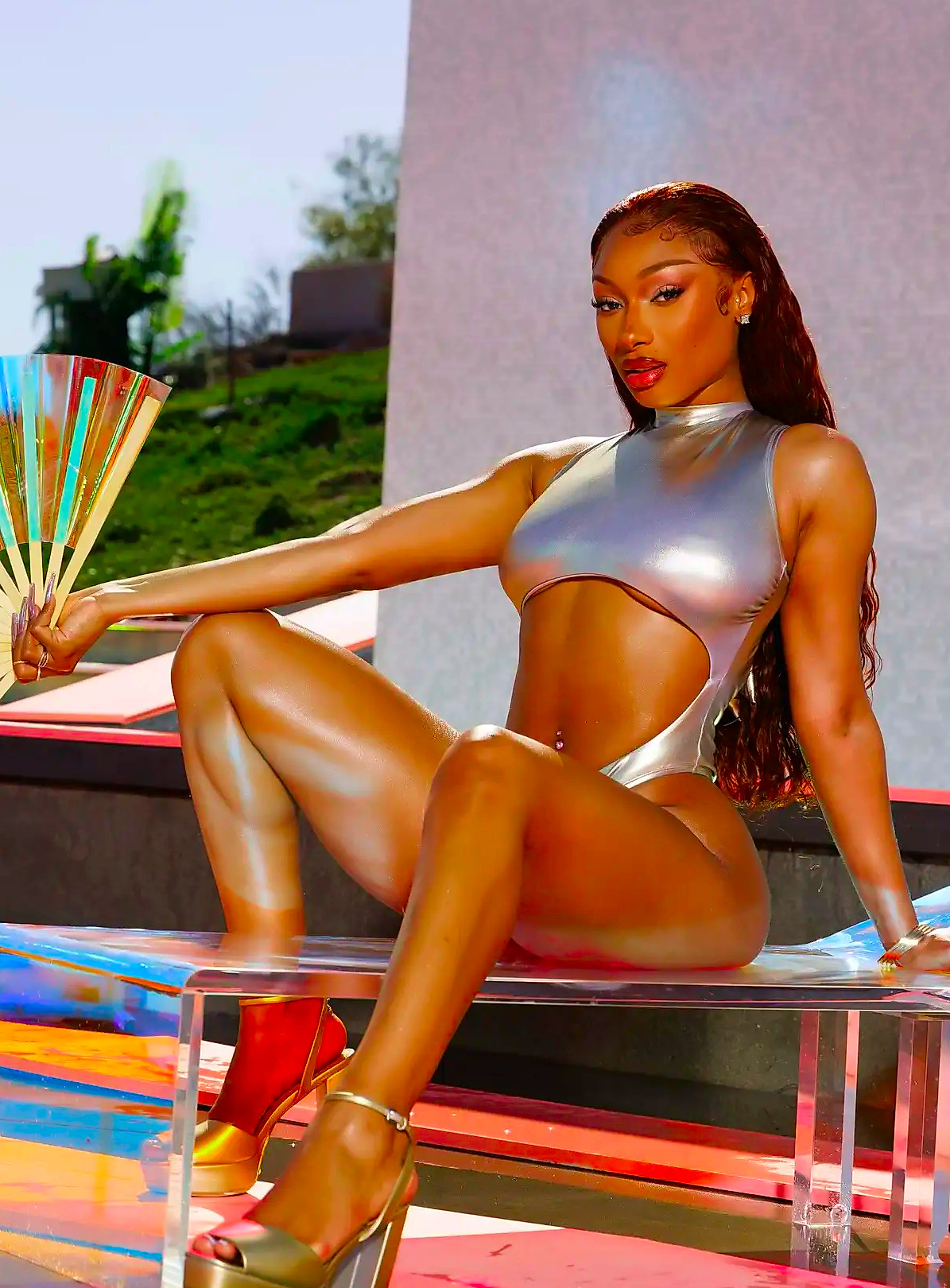 Megan Thee Stallion wearing a gold swimsuit