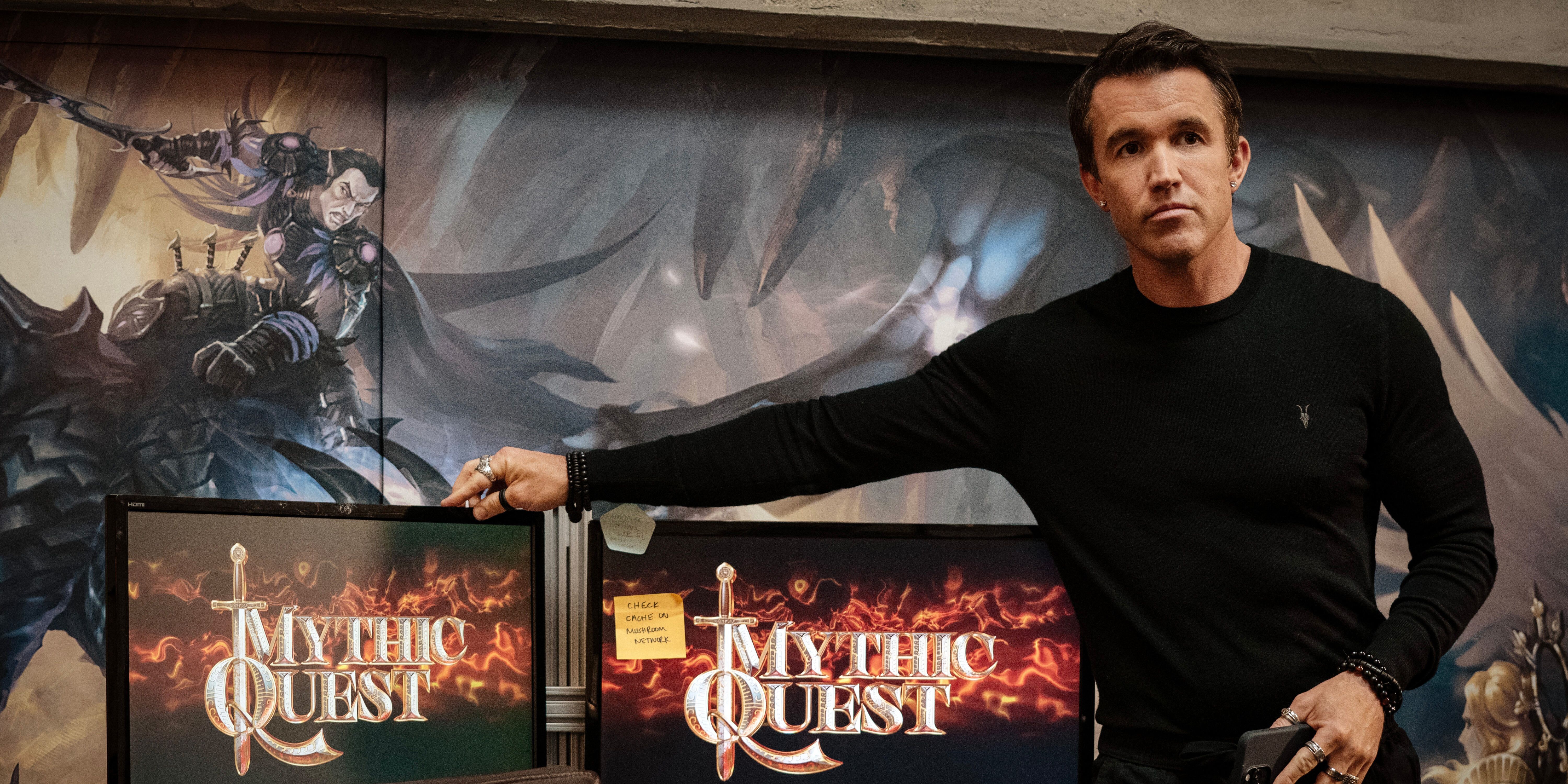 Ian Grimm (Rob McElhenney), wearing a black shirt, stands by a computer in Mythic Quest Season 4