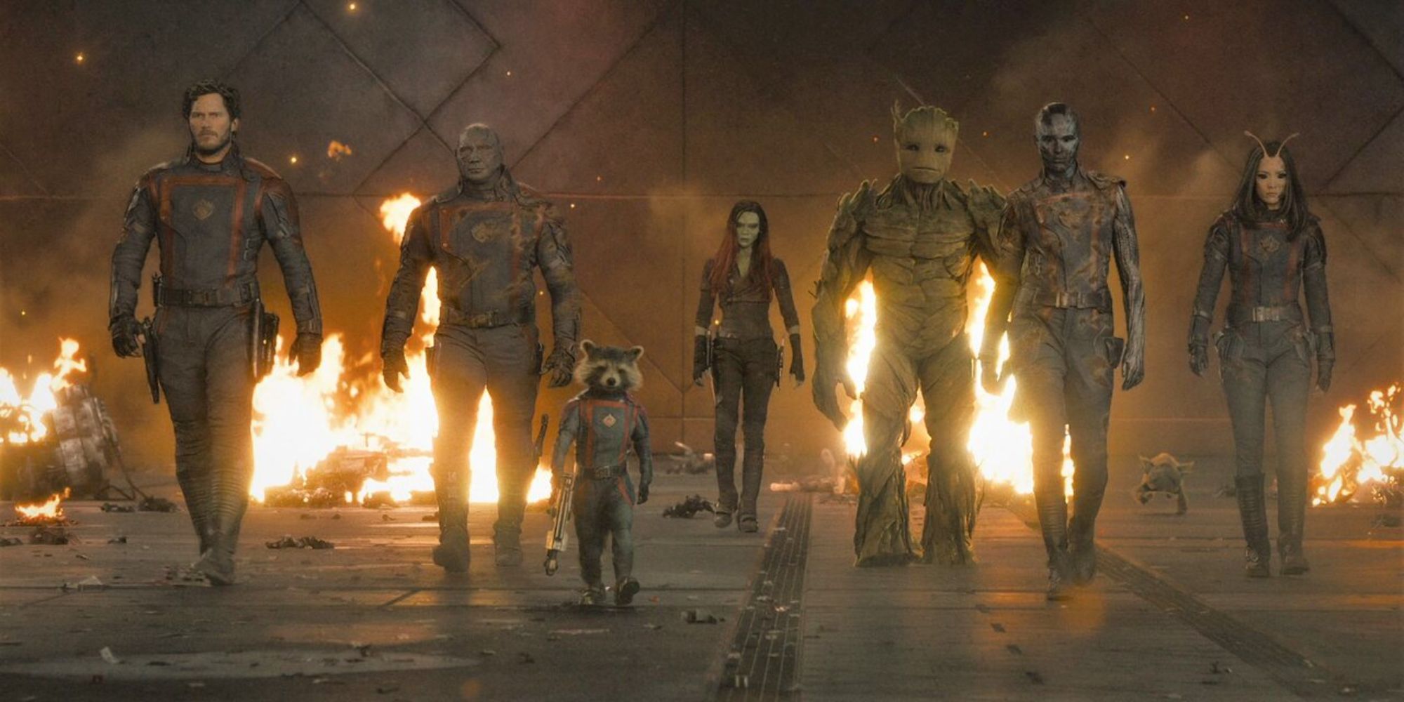 The Guardians walking towards the camera with several small fires in the background in Guardians of the Galaxy- vol. 3