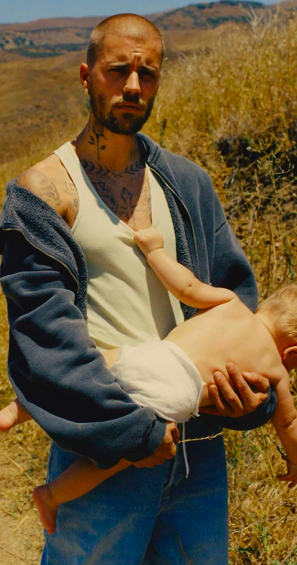 a man holding a baby in a natural outdoor setting