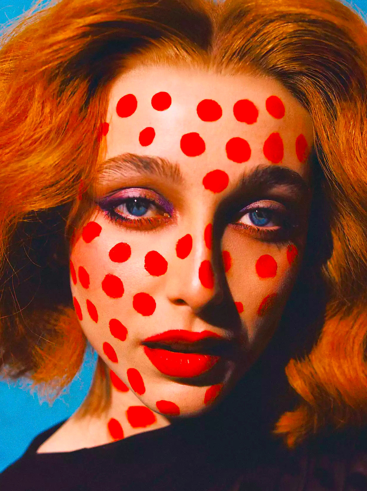 Emma Chamberlain in a red wig with red spots on her face.