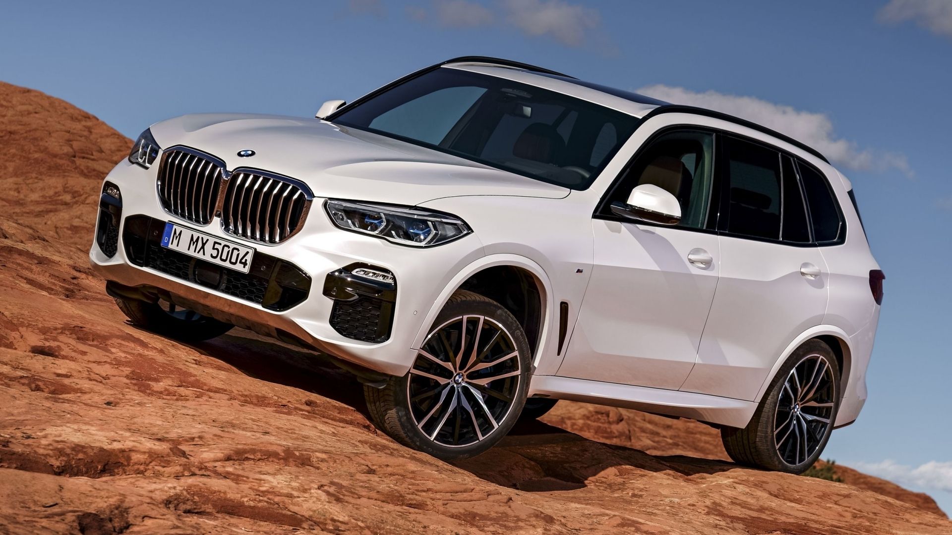 2018 BMW X5 in white traversing desert dune